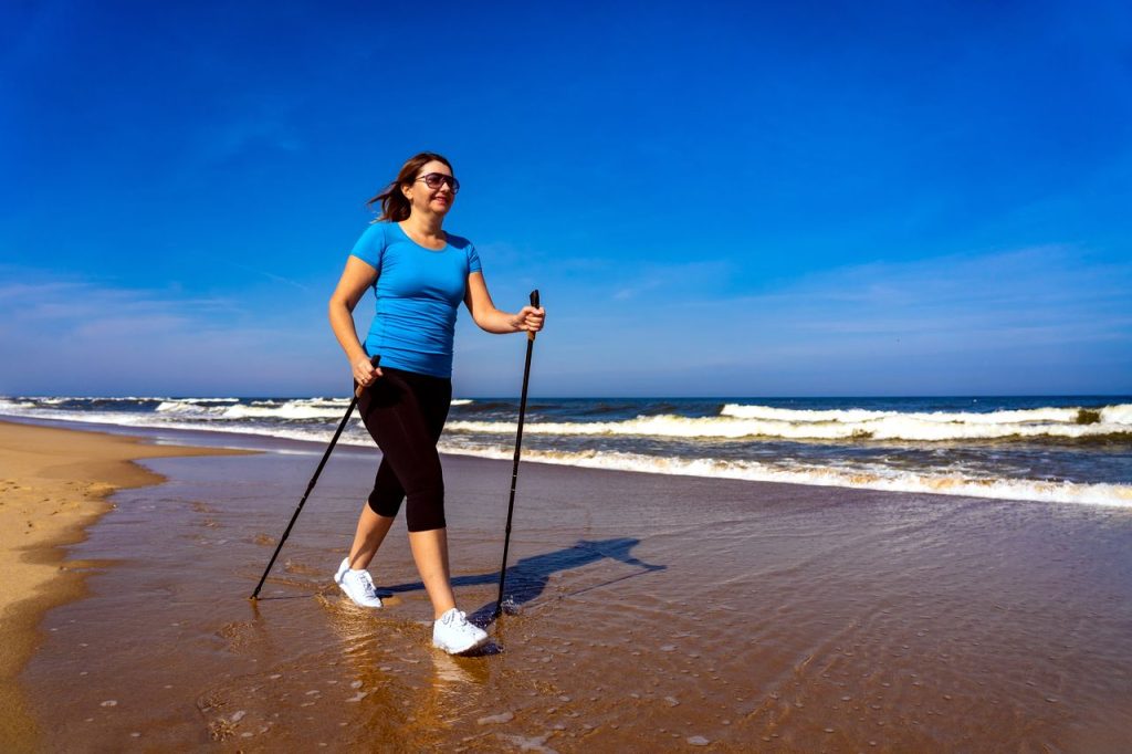 femme qui fait de la marche nordique avec des baskets